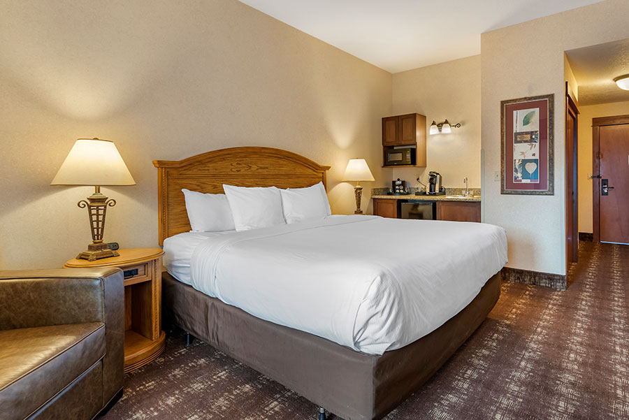 guest room with one king bed and wet bar