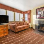 guest suite living area with sofa, fireplace, and TV